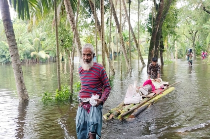 ‌ঘরে হাঁটু পানি, কলার ভেলায় বৃদ্ধাকে নিয়ে আশ্রয় খুঁজছেন তারা